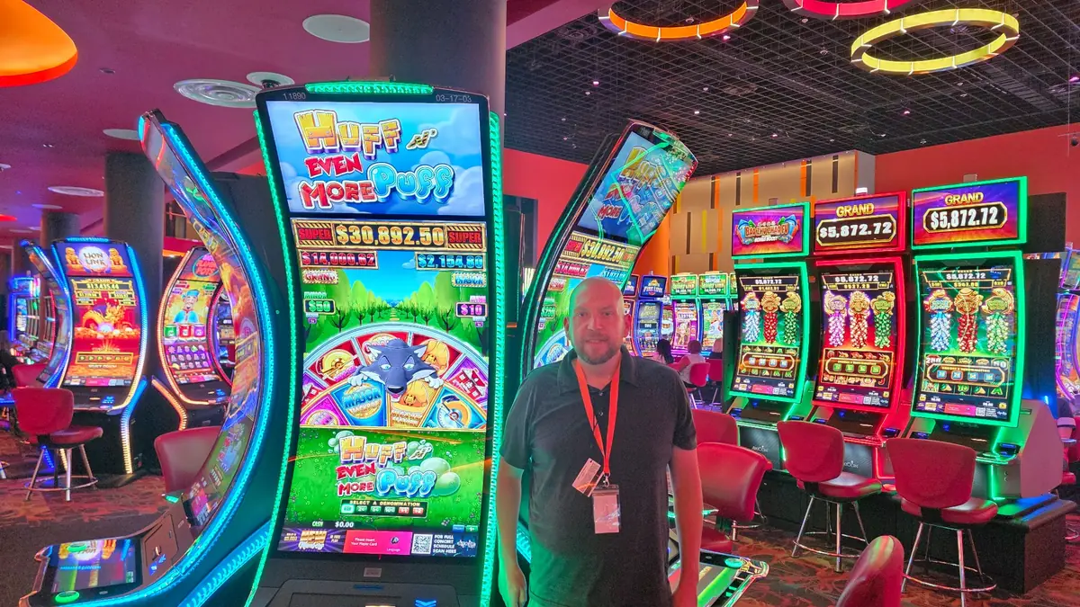 Wojtek beside a Huff N’ Even More Puff slot machine at The Casino @ Dania Beach.