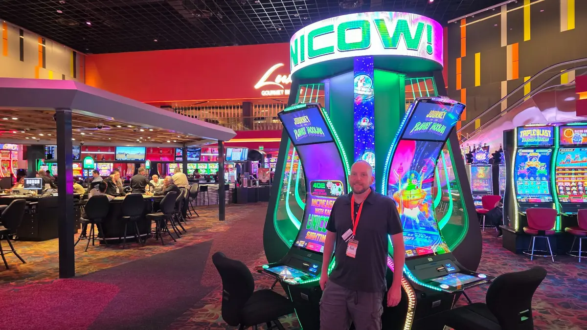 Wojtek beside the Journey to the Planet Moolah slot bank at The Casino @ Dania Beach.