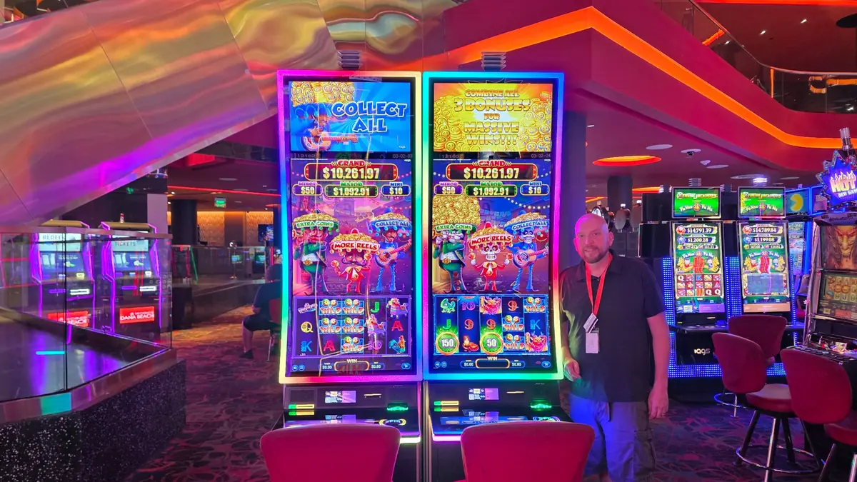 Wojtek beside two Mariachi Fortunes Trio slot machines at The Casino @ Dania Beach.