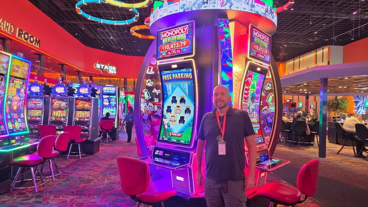 Wojtek beside the large MONOPOLY Big Board Bucks slot installation at The Casino @ Dania Beach.