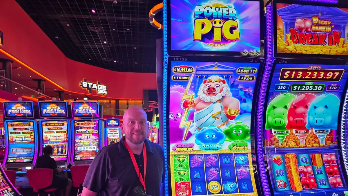 Wojtek beside the Power Pig slot machine, with Piggy Bankin’ Break In visible on the right at The Casino @ Dania Beach.